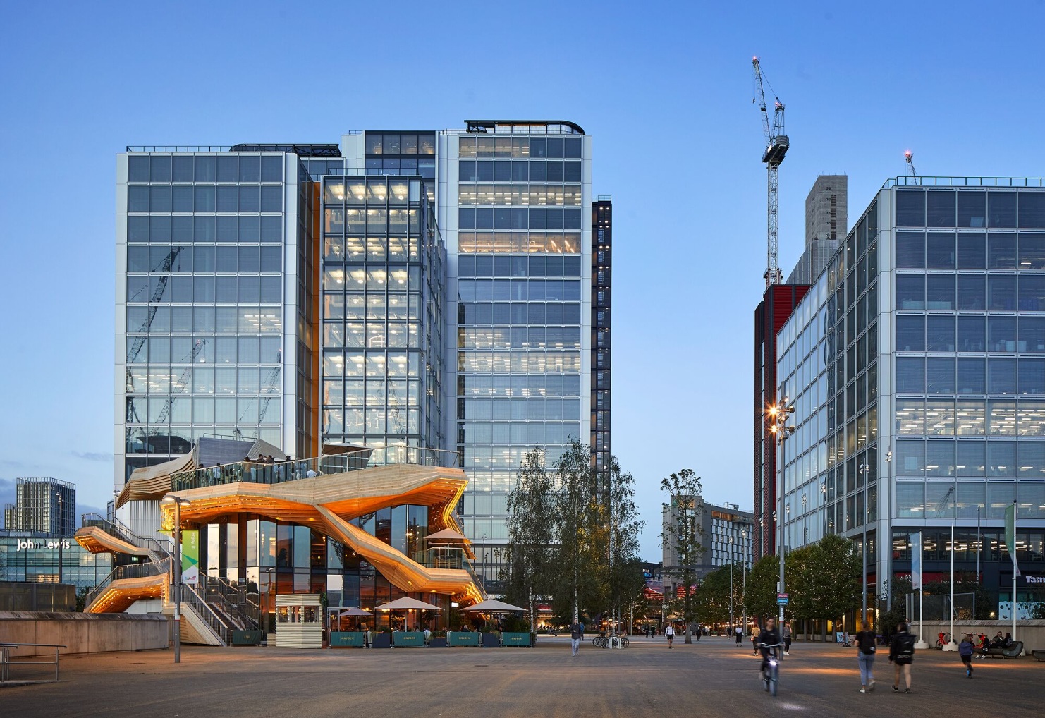 IQL Pavilion in front of high-rise buildings with glass facade at dusk