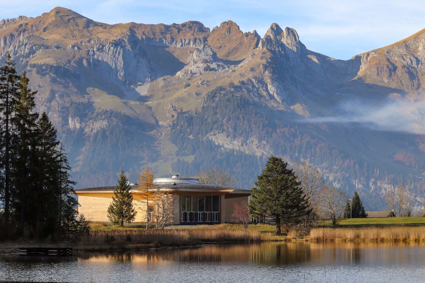 Außenansicht des Klanghauses Toggenburg mit Blick auf See und markante Berglandschaft