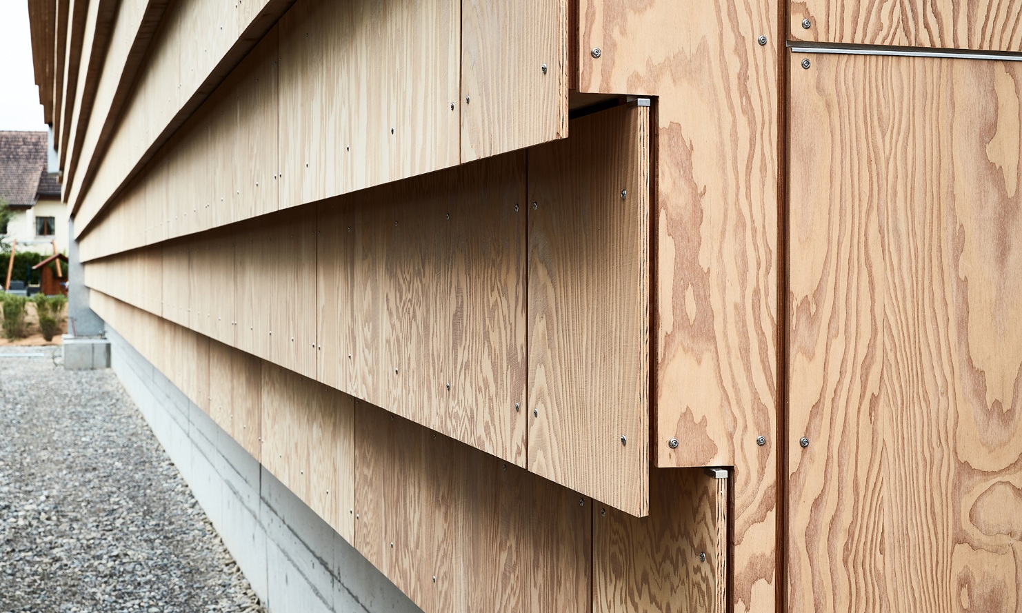 Une vue détaillée des grands panneaux de façade en bois de l'entrepôt.