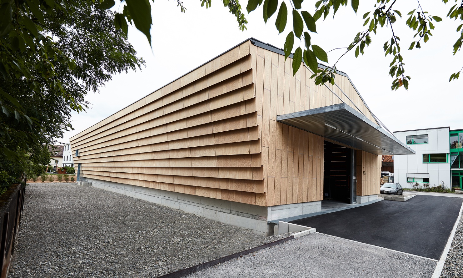 Le nouveau hall industriel et de stockage d'Hortima avec une façade en bois frappante dans la vue générale.