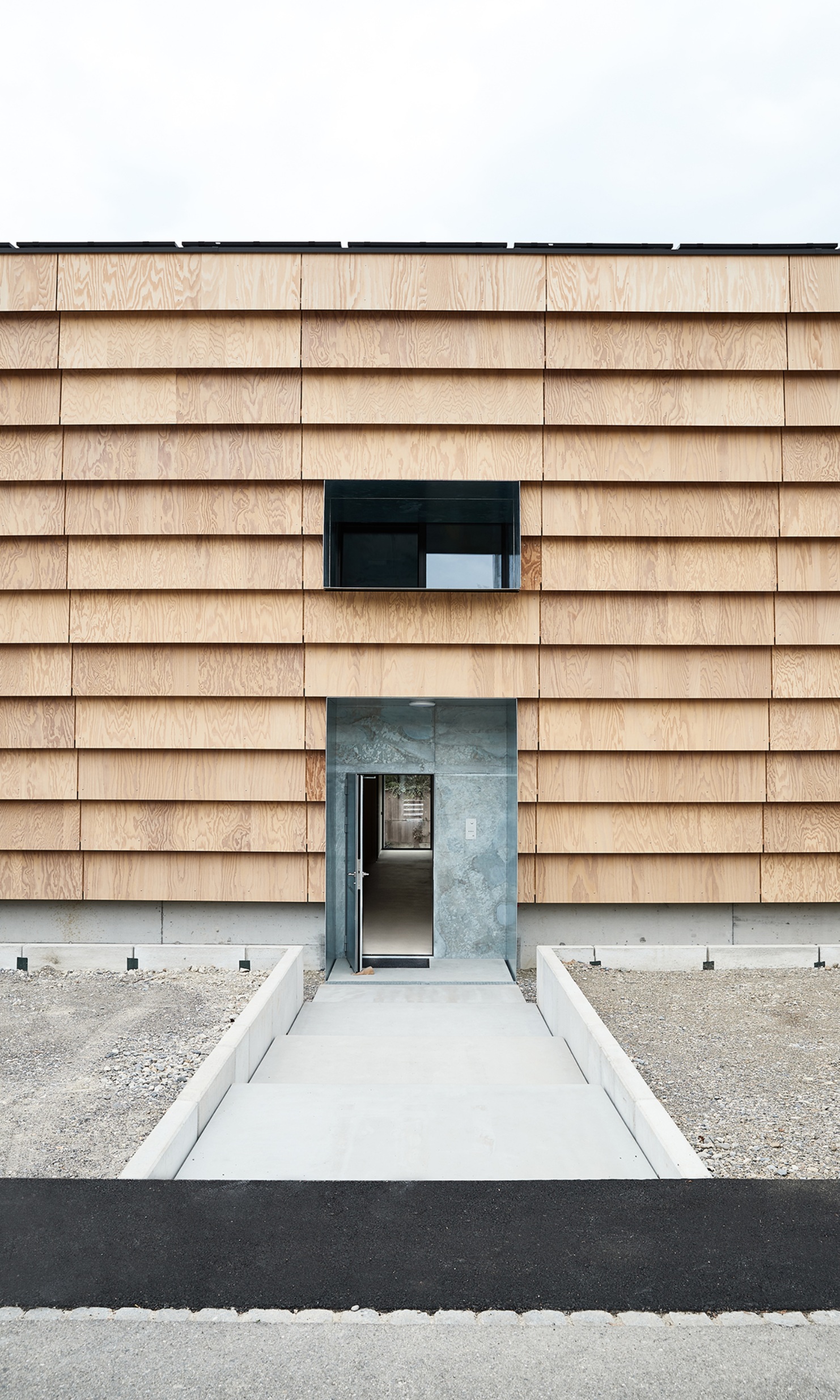 Entrée du personnel de l'entrepôt d'Hortima avec fenêtre au-dessus dans la façade en bois.