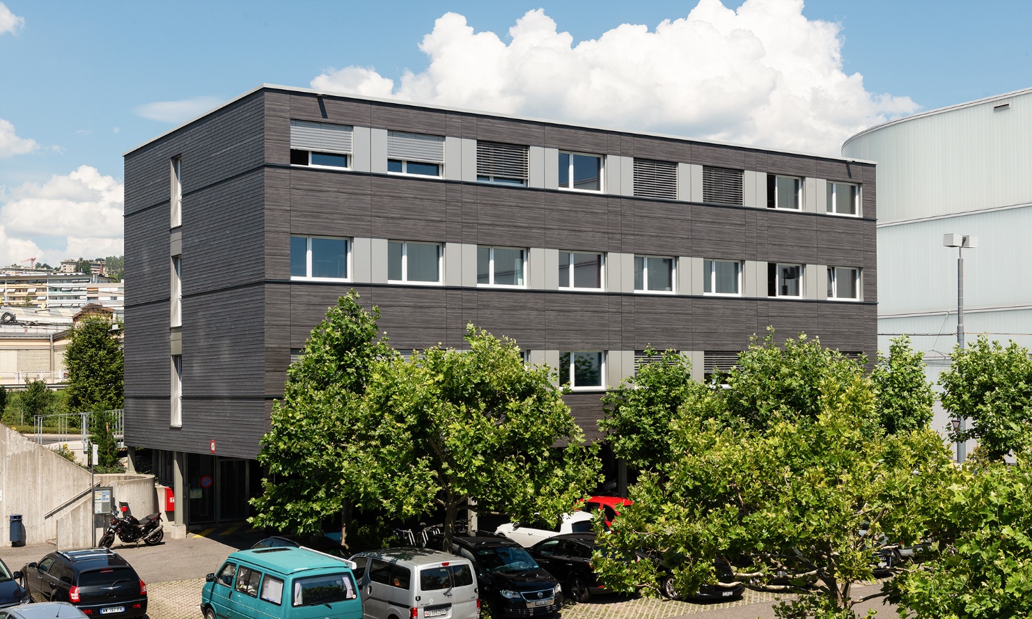 Three-storey modular construction with a dark timber facade serves as the office building for Lausanne transport authority