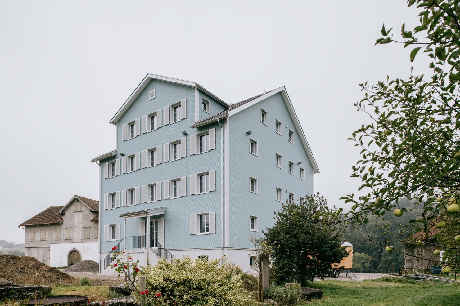 Four-storey apartment building with light blue eternit facade