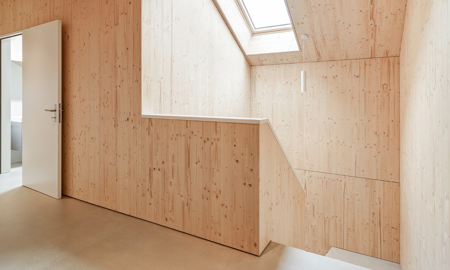 Bright staircase made entirely of wood in one of the apartments in the Quellenhof apartment building