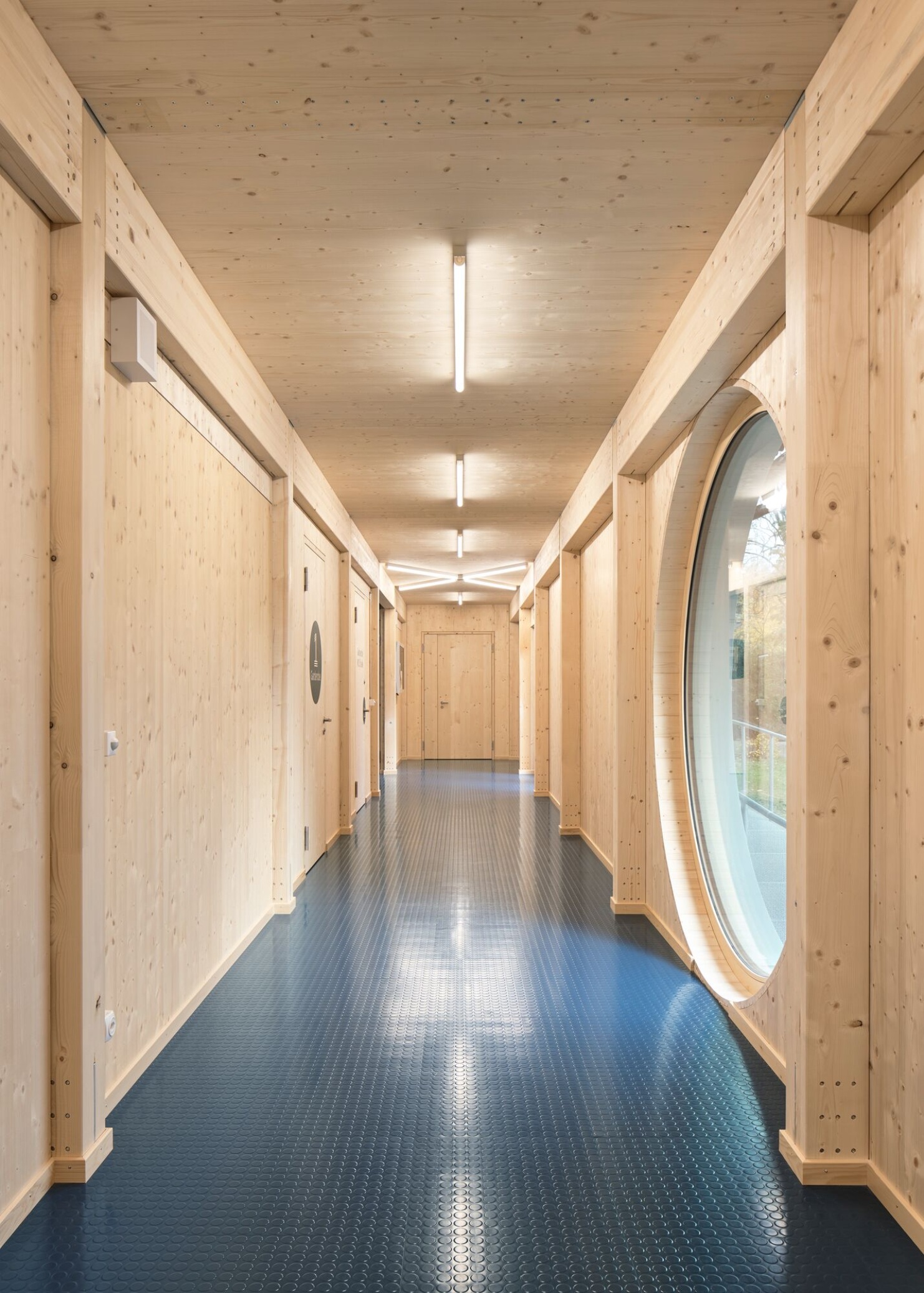 Couloir avec murs et plafond en bois dans le gymnase.