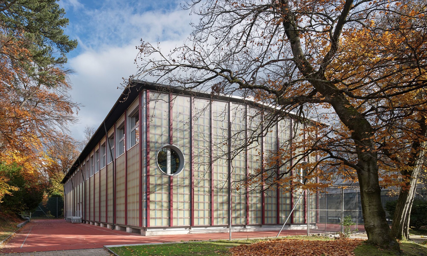 Die temporäre Sporthalle Enge mit vertikaler Holzkonstruktion in Herbststimmung