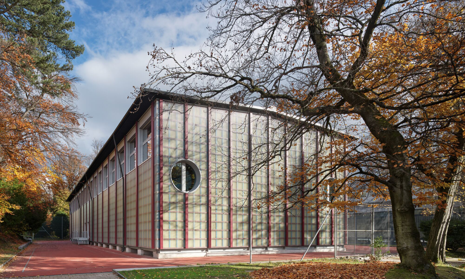Die temporäre Sporthalle Enge mit vertikaler Holzkonstruktion in Herbststimmung