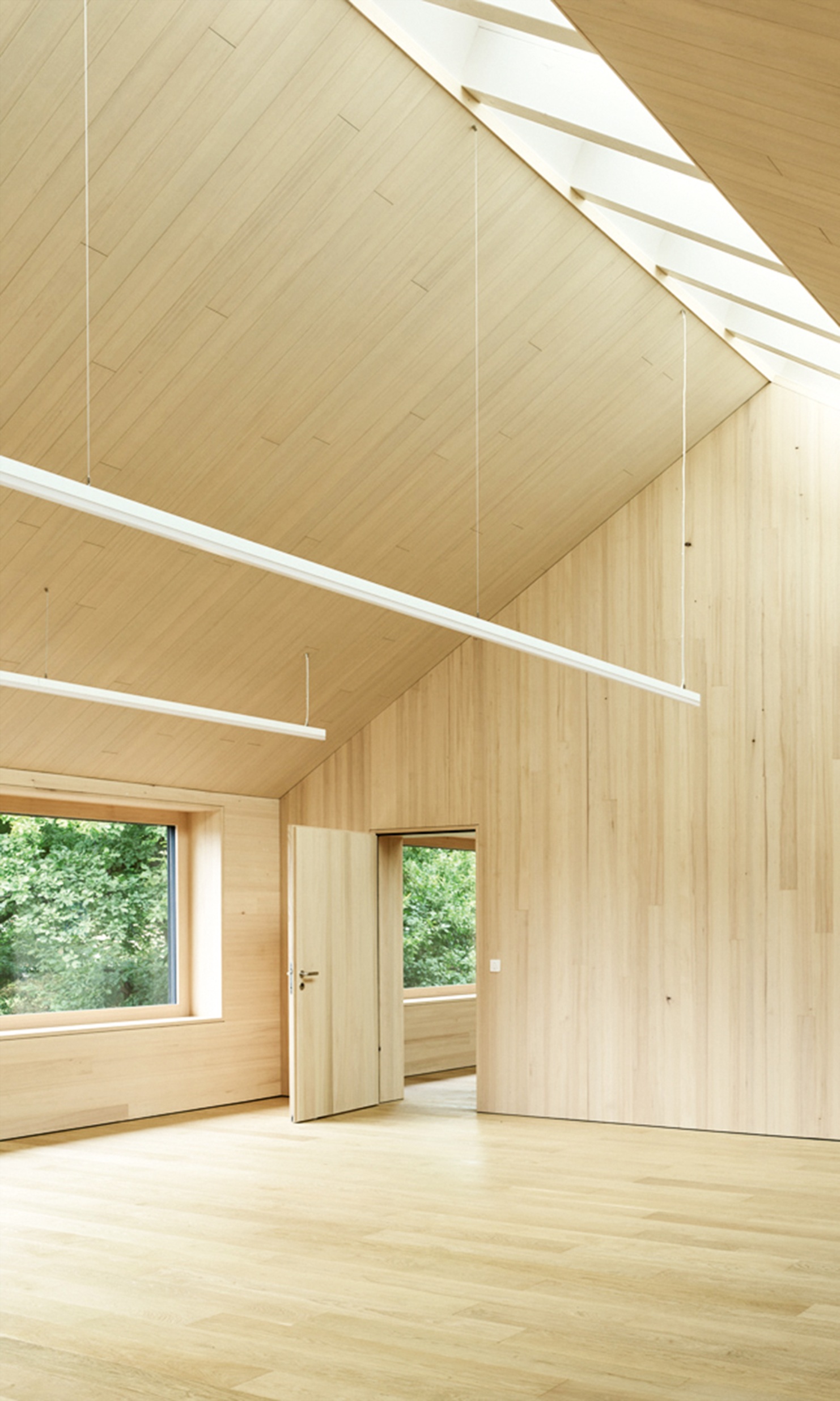 Hauts plafonds avec aménagement intérieur en bois et lumière naturelle au plafond