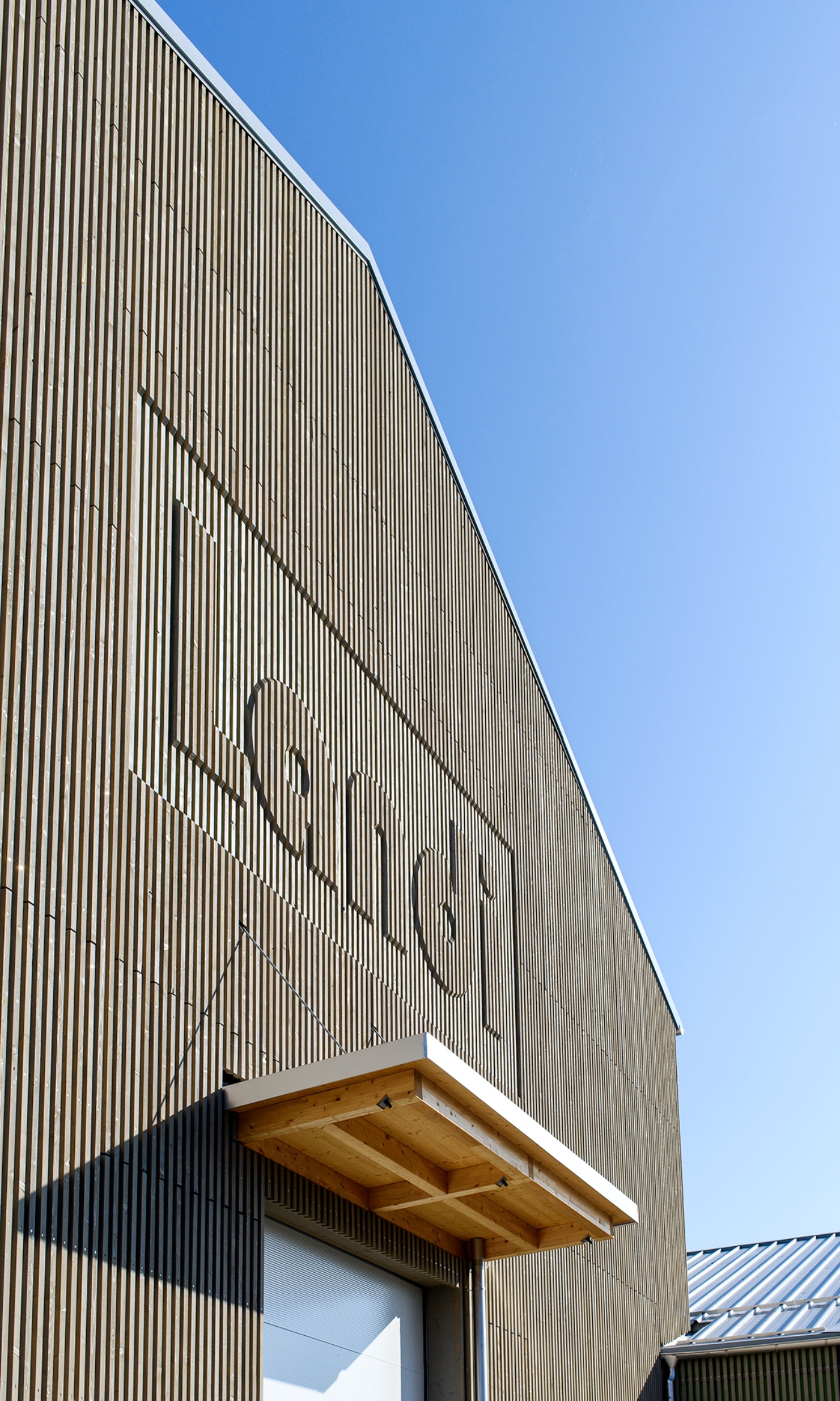 La prise de vue montre la façade avec les coordonnées du magasin Landi travaillées dans le bois.