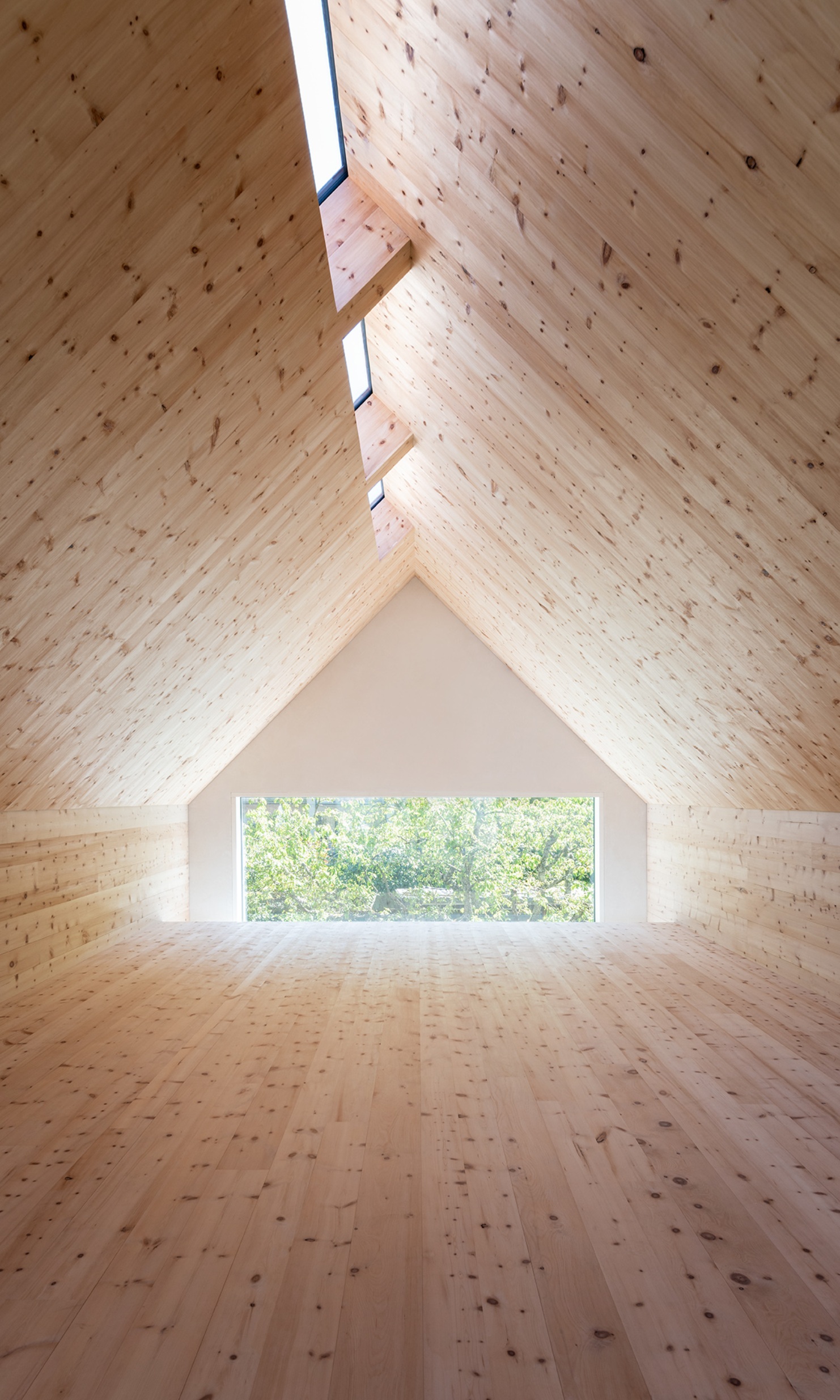 Pièce entièrement revêtue de bois d’arole, inondée de lumière naturelle dans les combles de la Sutra House.<br/><br/>