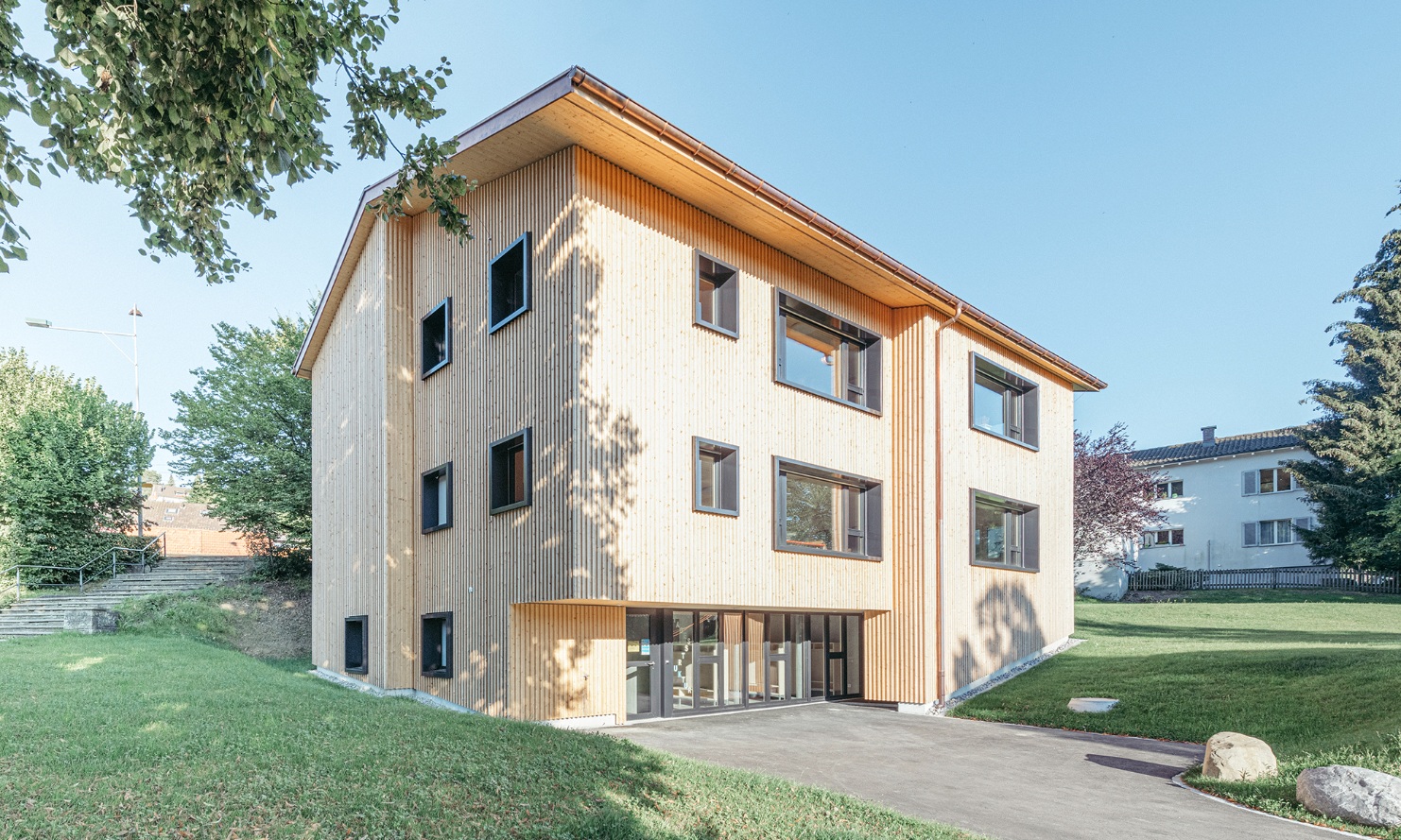 Overall view of the new three-storey daycare centre with timber facade