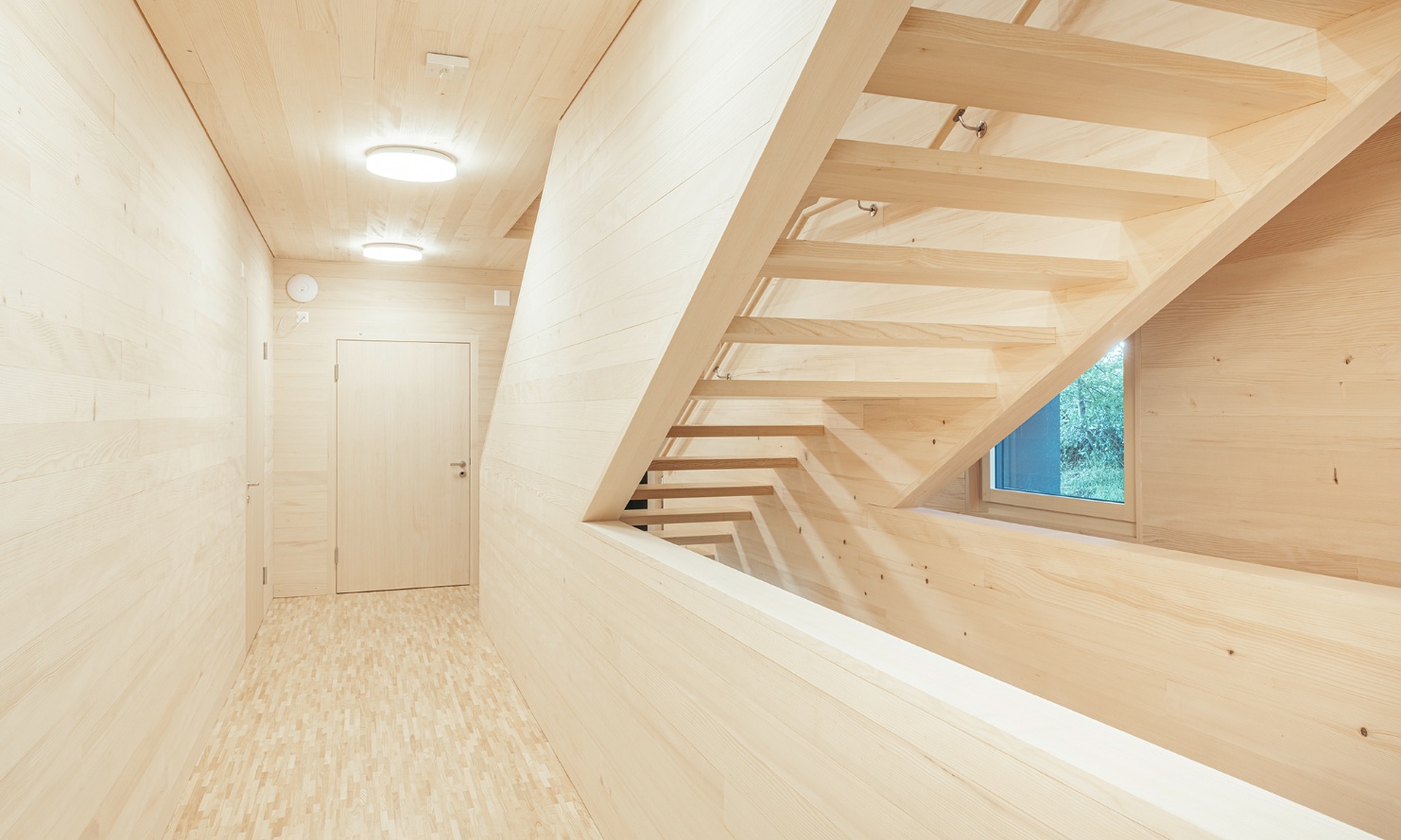 Les escaliers et le couloir, y compris les murs, les planchers et le plafond, sont entièrement en bois dans le nouveau bâtiment des structures d’accueil de jour