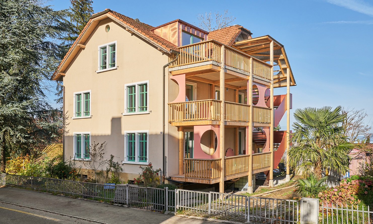 Recyceltes Mehrfamilienhaus mit neuem Treppenturm und Laubengängen aus Holz 