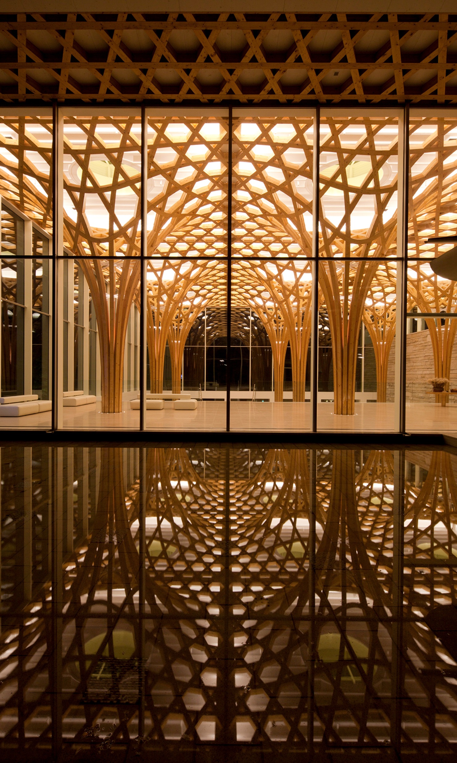 View of the illuminated supporting structure at night with reflections on the floor 