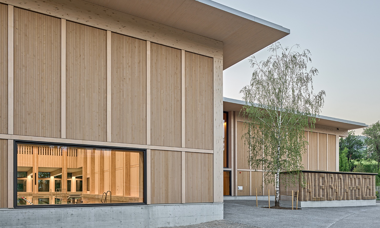 Façade en bois de la piscine couverte d'Appenzell avec vue sur l'intérieur