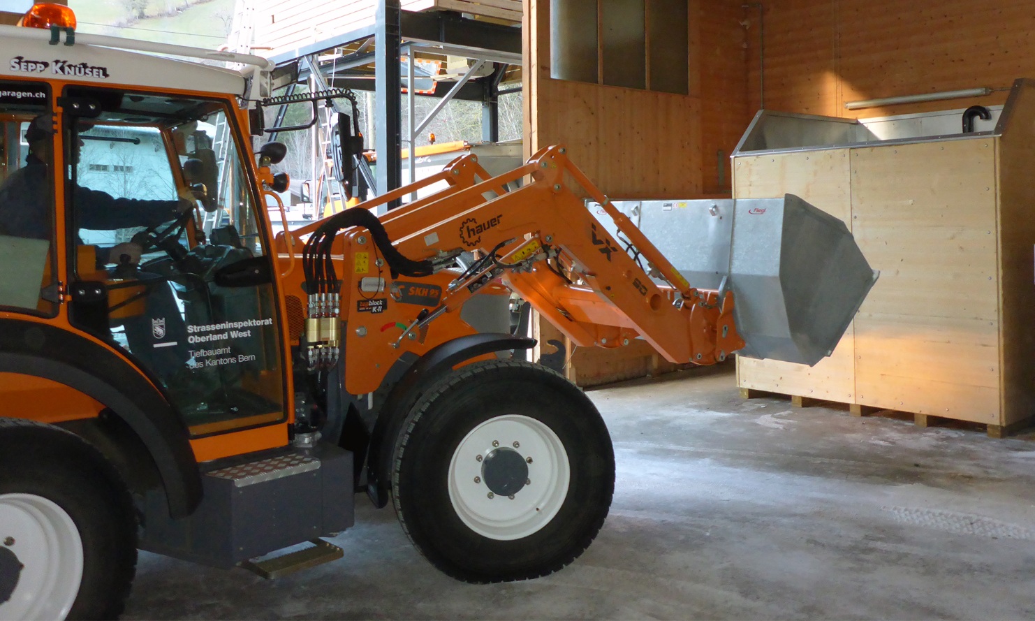 A tractor feeds a module conveyor system with salt