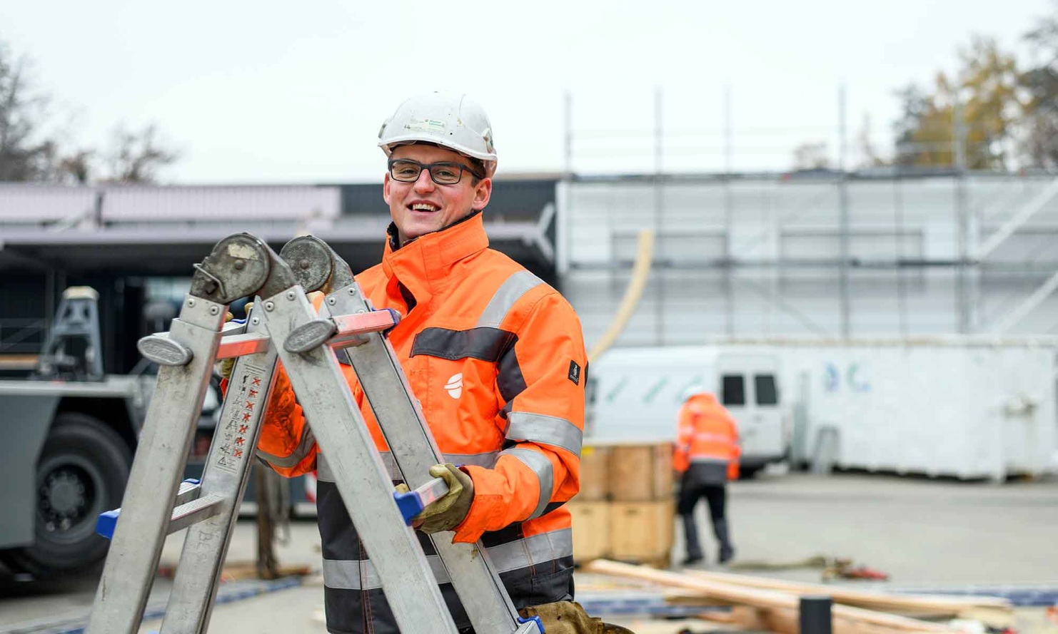 Assembly worker with a ladder during the assembly of a round timber silo