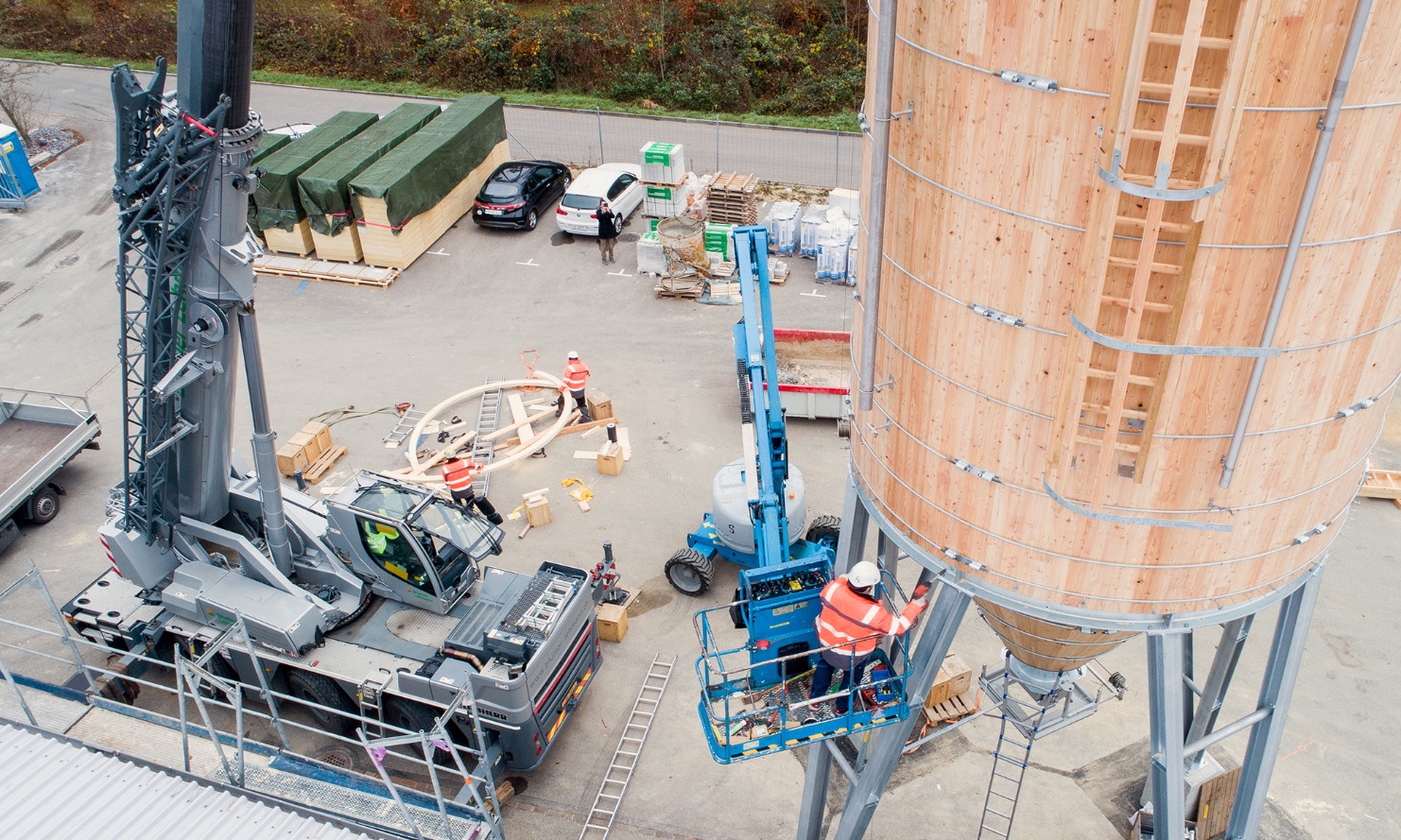 Montagemitarbeiter in Hebebühne bei Schraubarbeiten am Silo