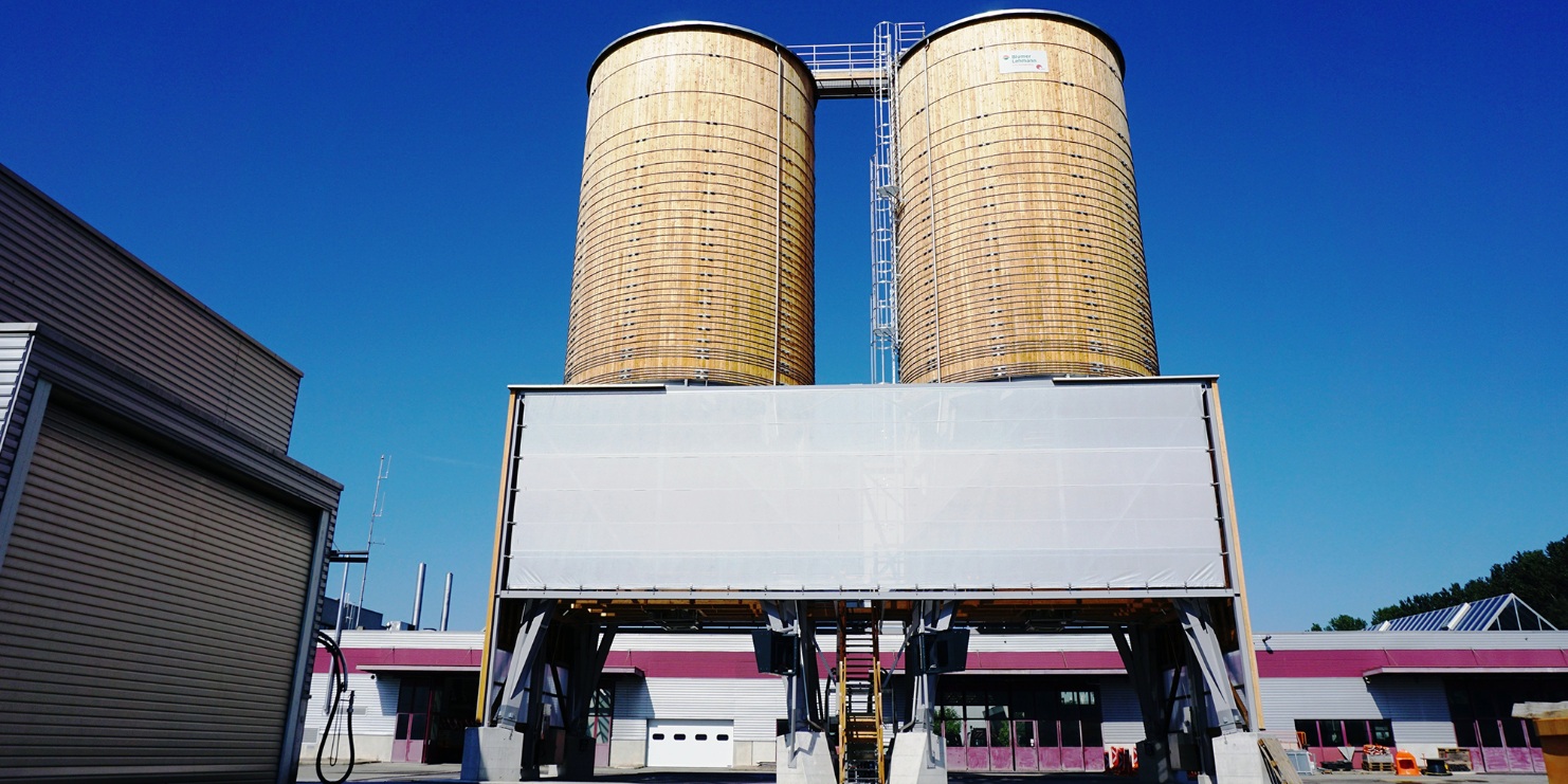 Installation complète à Domdidier (CH) composée de deux silos ronds en bois reliés par des estrades en bois sur le toit, avec centrale à saumure et système automatique 