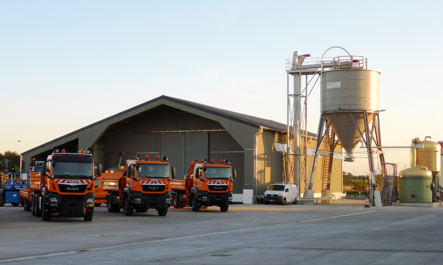 Gesamtanlage in Fahrbinde (DE) bestehend aus einer Lagerhalle und einem Silo aus Holz und einer Soleanlage, davor sind drei Lastwagen auf den Winterdienst parkiert