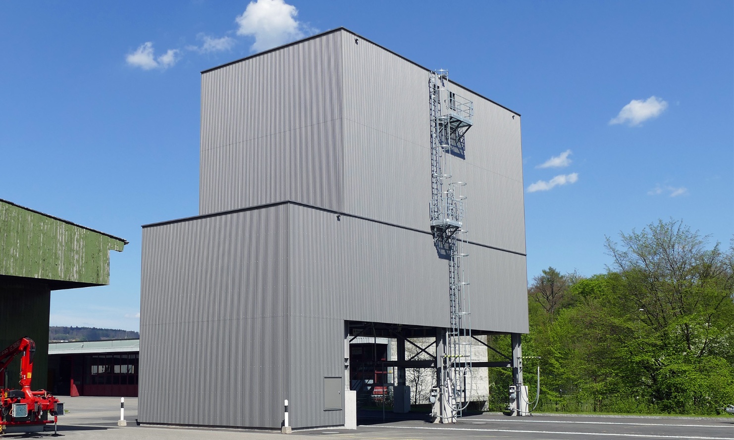 Light grey, architectural 450 m³ modular silo with steel ladder, at a maintenance depot