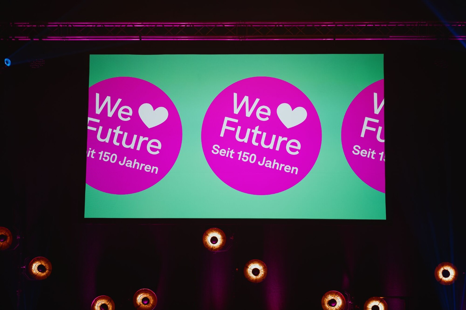 Leinwand mit dem Jubilaeumslogo „We love Future – Seit 150 Jahren“ beim Event von Blumer Lehmann.