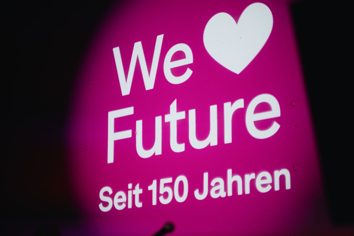 Leuchtend pinkes Logo „We love Future – Seit 150 Jahren“ als Lichtprojektion beim Jubilaeum von Blumer Lehmann.
