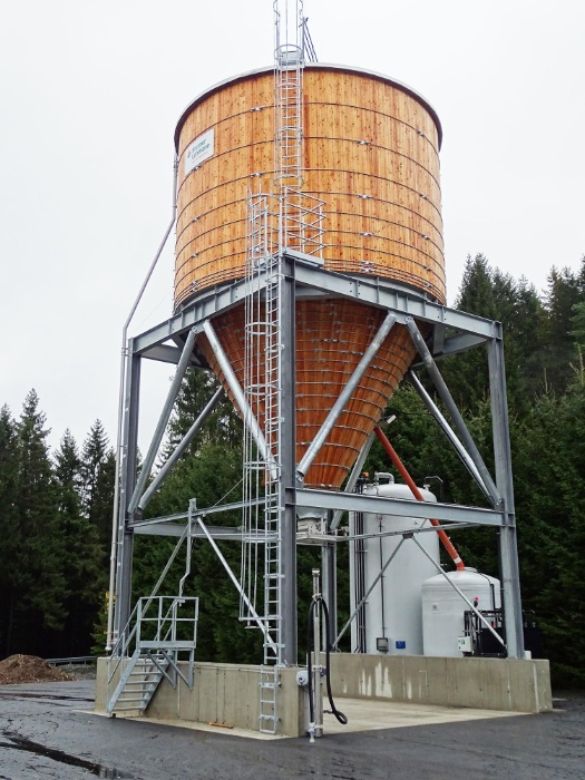 Runder Silo aus Holz auf einem kubischen und feuerverzinkten Stahlunterbau