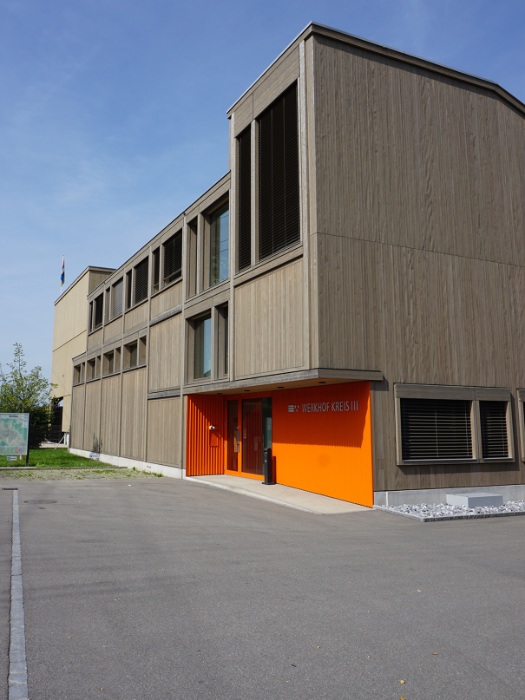 Le silo modulaire, avec sa façade en mélèze pré-grisé, s'intègre harmonieusement au bâtiment existant du chantier. 