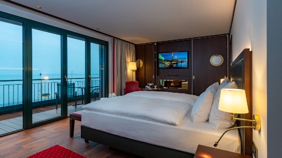 Grosszügiges Gästezimmer im Hotel Bad Horn; mit Doppelbett und grosser Fensterfront und Balkon