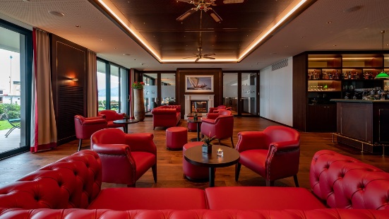 Lounge und Bar im Hotel Bad Horn mit roten Sitzmöbeln und indirekter Deckenbeleuchtung 
