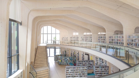 Grosser, heller Raum mit Treppe und Bücherregalen 