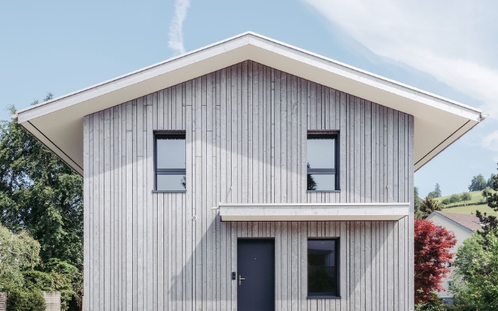 Exterior view of the detached house: an abundance of wood in different structures and colours.