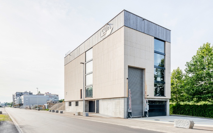 Overall view of the four-story energy plant with vertical facade featuring rough-cut, tongue-and-groove boarding. 