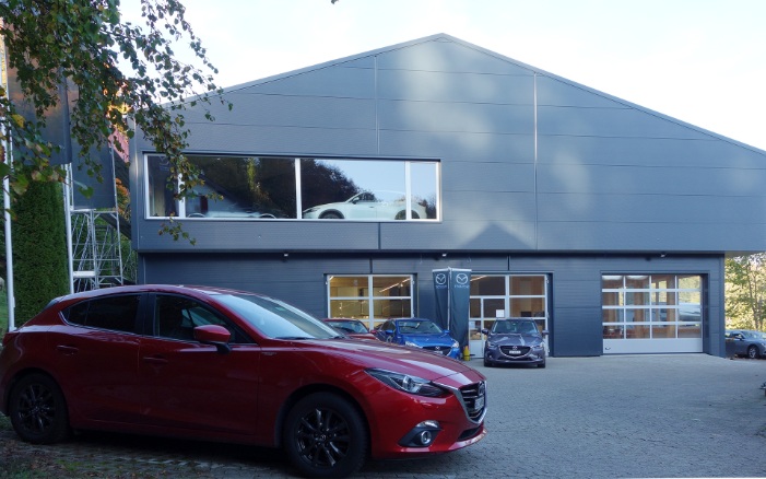 Gesamtansicht der Mazda-Garage mit parkiertem Auto davor