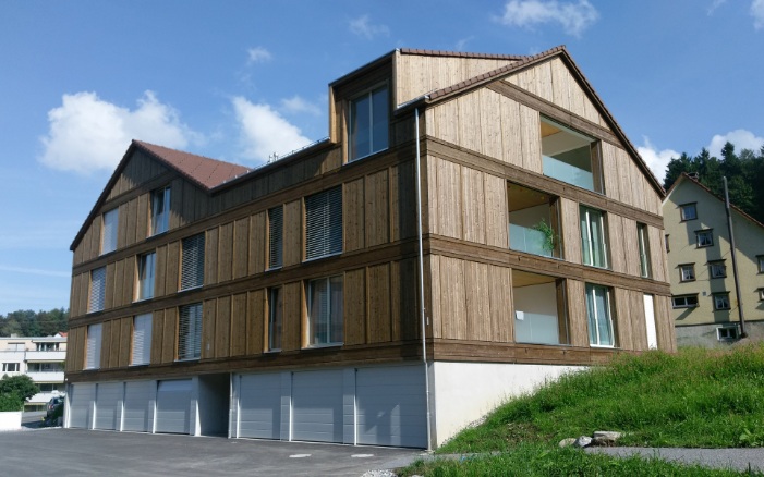 The photograph shows the forecourt and garage spaces of the Mattenbach apartment building in Grub
