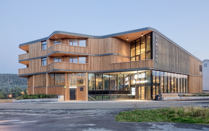 Three-storey ‘Samling’ library building with its curved timber construction, seen in the evening light 