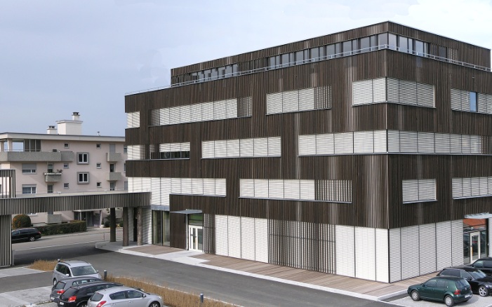 Vue d’ensemble de l’immeuble de bureaux Braun AG avec le parvis pour les places de stationnement et la zone d’entrée