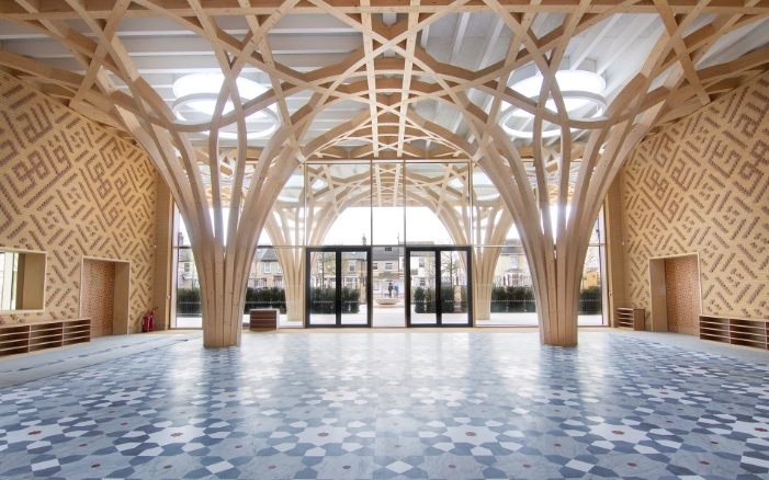 The tree-like wooden supporting structure dominates the entrance area of the Cambridge Mosque. The floor is designed as a grey/blue tiled mosaic while the walls are of two-coloured clinker brick with oriental motifs.