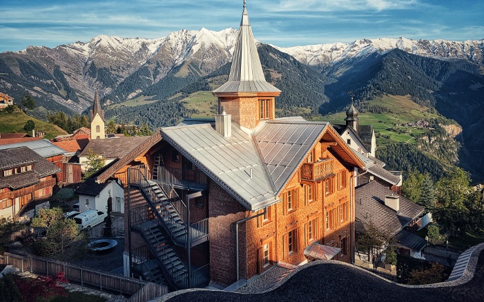 Im Bündner Dorf Morissen, mit den Bergen im Hintergrund: das sanierte und umgebaute Guesthouse Lampart’s Val Lumnezia.