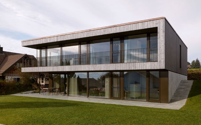 Maison individuelle moderne avec façade en bois et baie vitrée