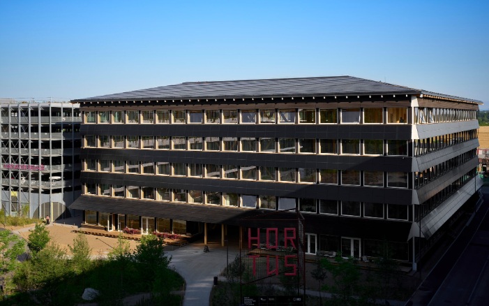 Overall view of the Hortus building with modern timber facade and red lettering in the foreground.