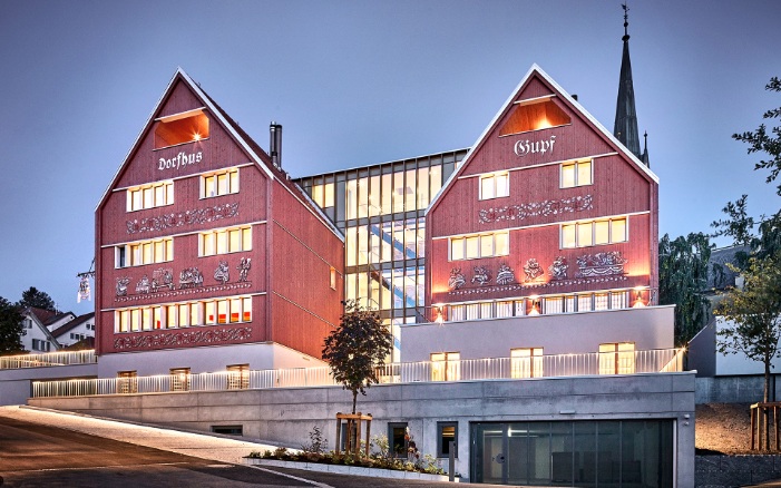 Hôtel Restaurant Dorfhus Gupf avec des fenêtres éclairées par la lumière du soir