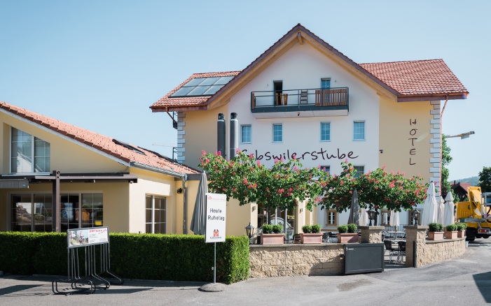 Gesamtansicht der Südfassade des neugebauten Hotels Gibswilerstube; mit Gartenrestaurant im Vordergrund.<br/><br/>