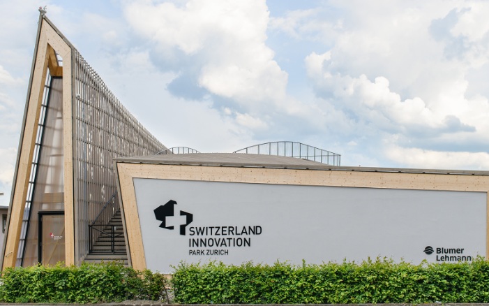 Blick auf den fertigen Bau des Switzerland Innovations Parks mit grüner Hecke. 