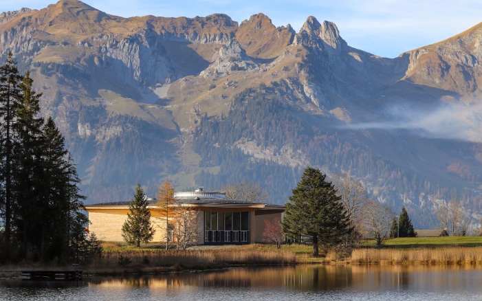 Exterior view of Klanghaus Toggenburg with lake and striking mountain backdrop
