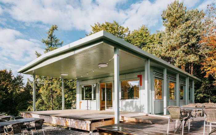 Pavillon du terrain de sport avec terrasse et sièges.