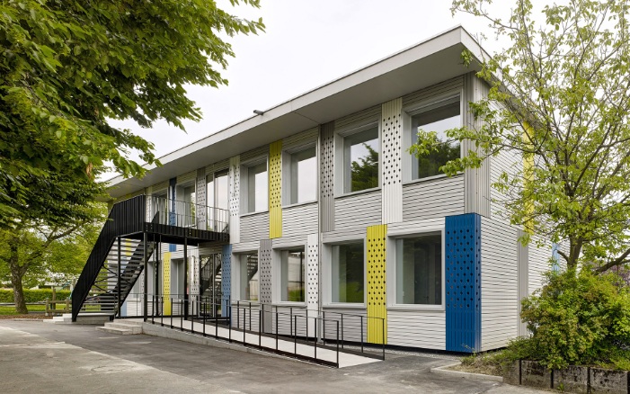Il n’y a pas que la salle de classe qui est pleine de vie, la façade de la construction modulaire est également très colorée.