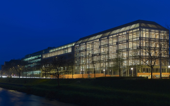 View of the entire Tamedia office building with evening ambience. The building is illuminated.