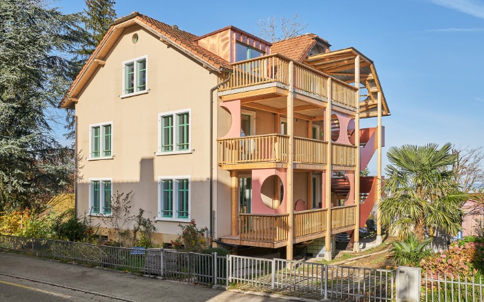 Recyceltes Mehrfamilienhaus mit neuem Treppenturm und Laubengängen aus Holz 